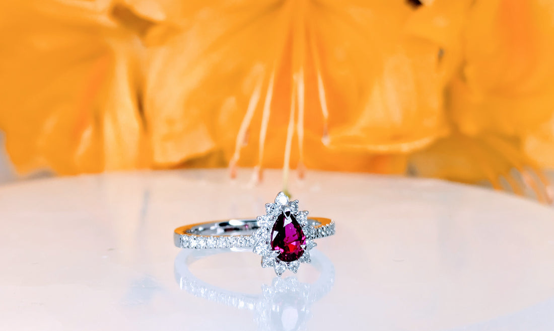 Ruby Unheated 0.25ct vivid red ruby on 18K white gold with a halo and band of 24 round collection diamonds at 0.28carats and 2.49 grams of gold.